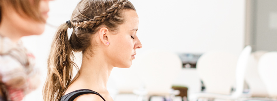 Kopfzeilenbild - Frau mit geschlossenen Augen bei Yogaübungen