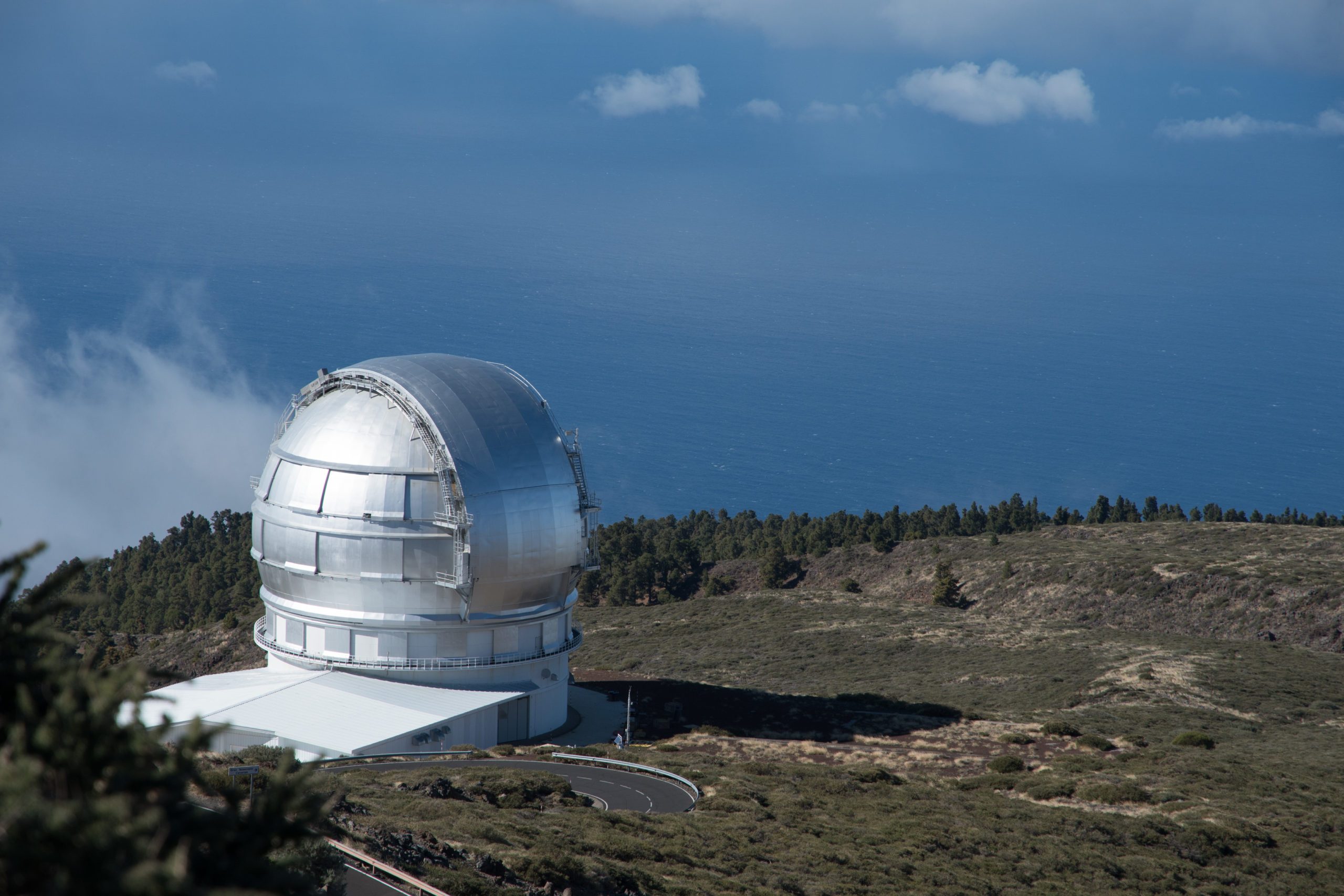 Silbernes Kuppelteleskop auf Insel vor blauem Himmel